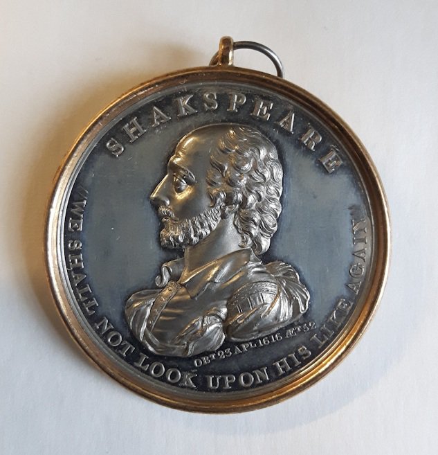 Shakespeare medal 1816. In the centre is  raised engraving of Shakespeare (short beard, high forehead, curled hair). At the top it says "Shakespeare" and round the bottom "We shall not look upon his like again".
