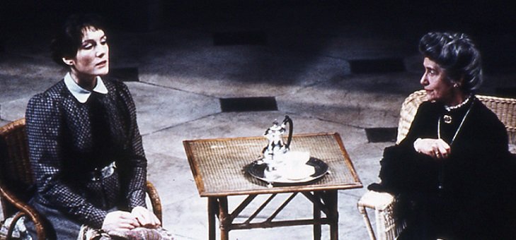 Two seated ladies confront each other across a small tea-table with a single tea or coffee pot and a single cup on a tray.