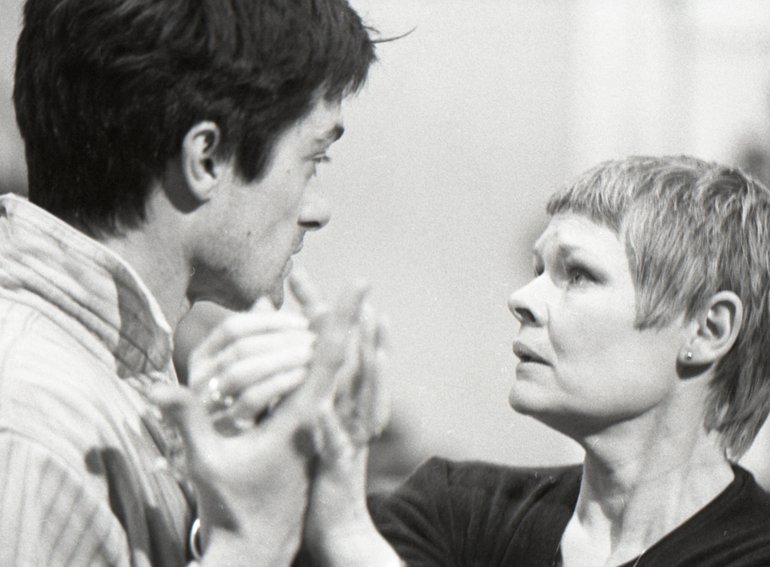 Cymbeline, Royal Shakespeare Company, 1979. In modern dress, Posthumus and Imogen stare into each other's eyes as they clasp hands before parting. (Innogen is quite clearly played by Judi Dench)