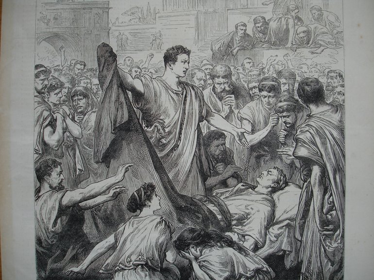 Mark Antony Stands in the centre, his right hand sweeping the cover from Caesar's body which is on a bed below him. He is surrounded by a crowd of figures, some of which show shock or disgust.