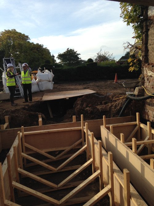 The image shows part of two wooden rectangles with evenly-spaced wooden upright on each side. 'V'-shaped beams join each pair of uprights.