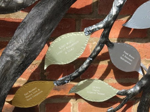 Four leaves are shown attached to the ends of twigs; they are coloured green, brown, and grey, and all have white writing in varying fonts.