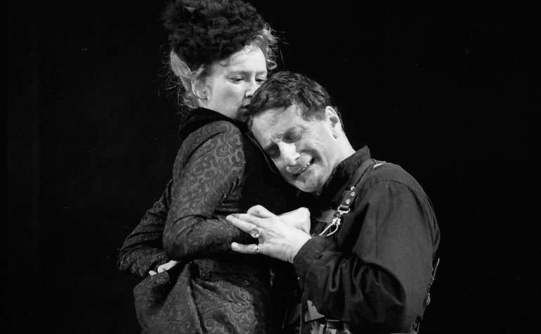 Richard is grasping Anne round the waist and holding her left wrist, as he leans his head against her shoulder. His eyes are closed and he is smiling; she looks down at him with a slight air of puzzlement.