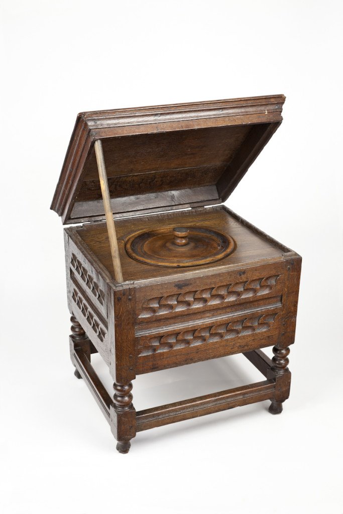 A late 17th century close stool or toilet in disguise made from English Oak. It is made up of a rectangular lid which sits on top of an engraved box. It is held up by wooden legs that are held together by stretchers.