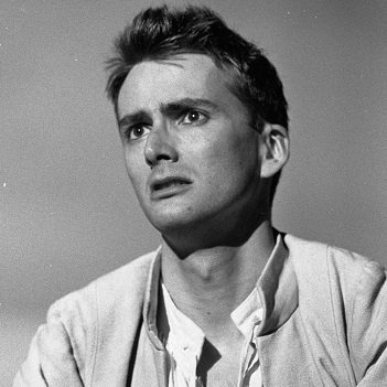 A dark-haired Romeo in modern dress stares wistfully at something in front of him.