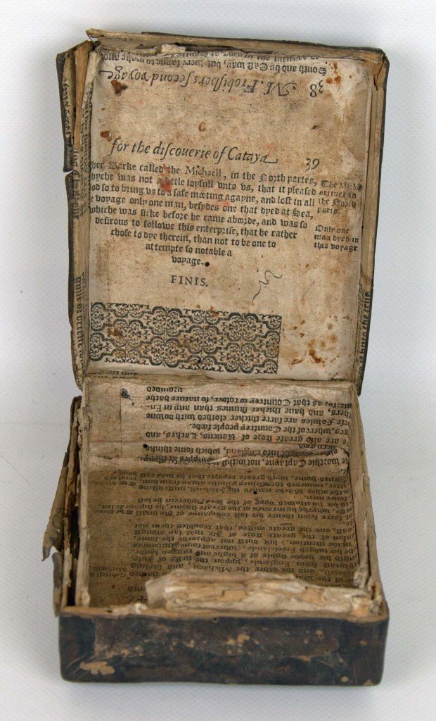 A death box lined in leather with loops to enable it to be attached to something. Inside the box is lined with pages of a story from M Frobisher's journey.