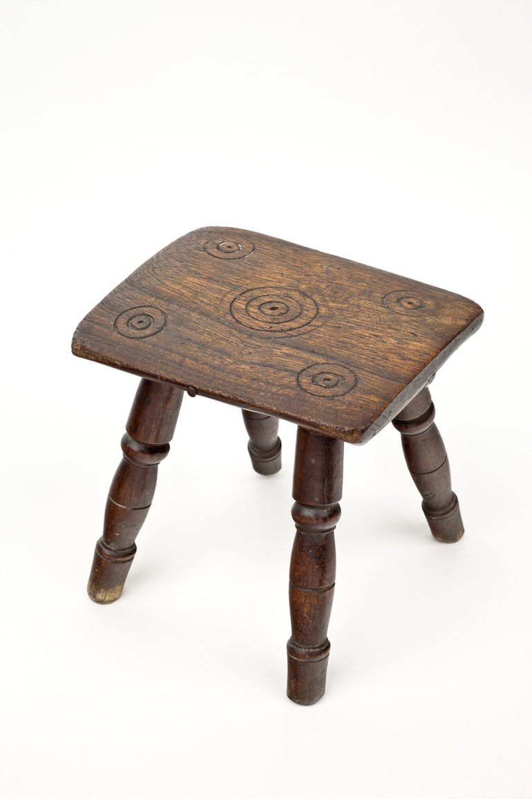 Witches Stool from Anne Hathaway's Cottage, C16th. Small wooden foot stool carved with five sets of rings known as 'Witches Marks'.