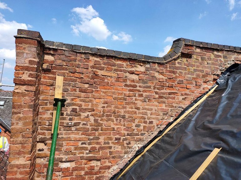 A brick parapet under repair at the rear of 19 Henley Street (Crystals).