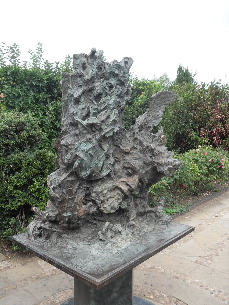 Greg Wyatt Sculpture of The Tempest. A very complex design, containing a ship, storm waves, a cleft tree and the wing of Ariel, and the bearded face of Prospero.